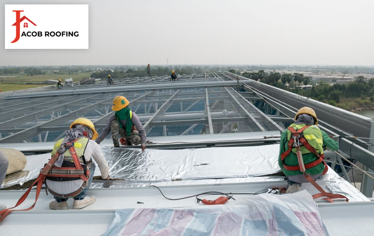 Worker installing EPDM roofing on a commercial building